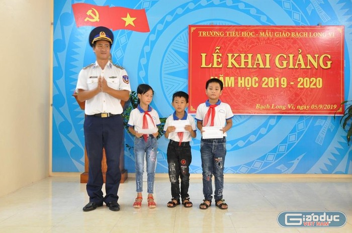 Đại diện Hải đoàn 11 - Vùng Cảnh sát biển 1 tặng quà các em học sinh của huyện đảo Bạch Long Vĩ