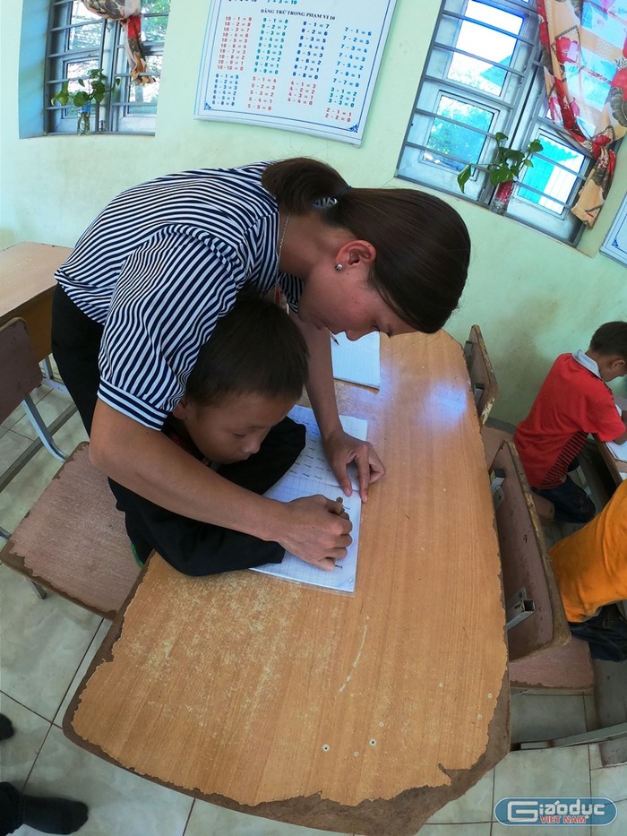 Cô giáo Lò Thị Vuông uốn nắn từng nét chữ cho từng em nhỏ người dân tộc thiểu số. (Ảnh: LC)