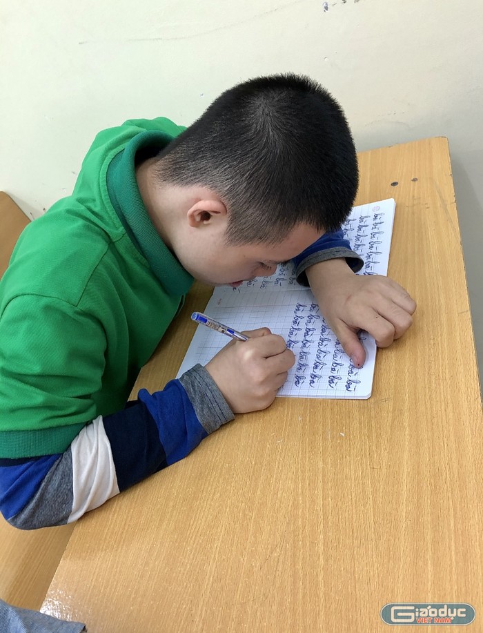 Các em học sinh khuyết tật trước đây không biết viết giờ đã có thể cầm bút viết thành thạo. Ảnh Ngọc Trang