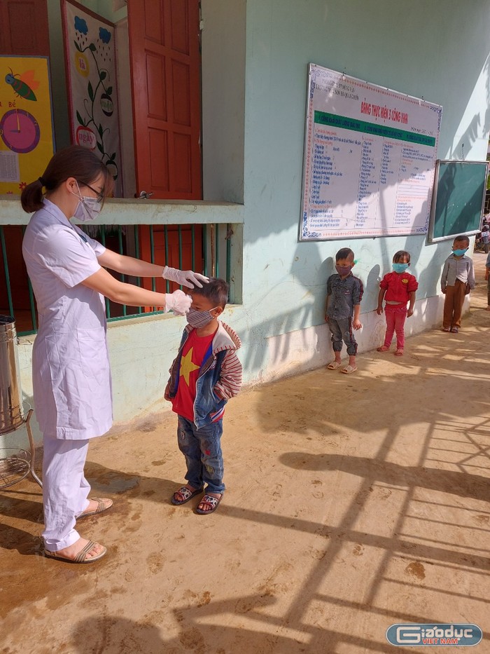 Nhân viên y tế tiến hành đo nhiệt độ các em học sinh tại trường Mầm non Hố Quáng Phìn.