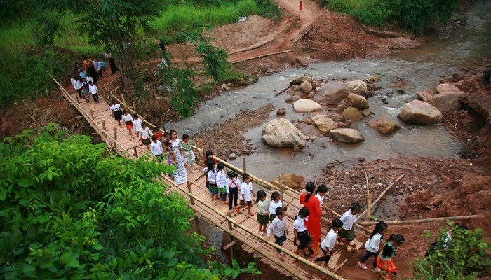 Ngay từ sáng sớm, các em đã đi qua cây cầu tạm do các cô giáo, phụ huynh dự lên. Ảnh các cô giáo trường Nậm Nhừ