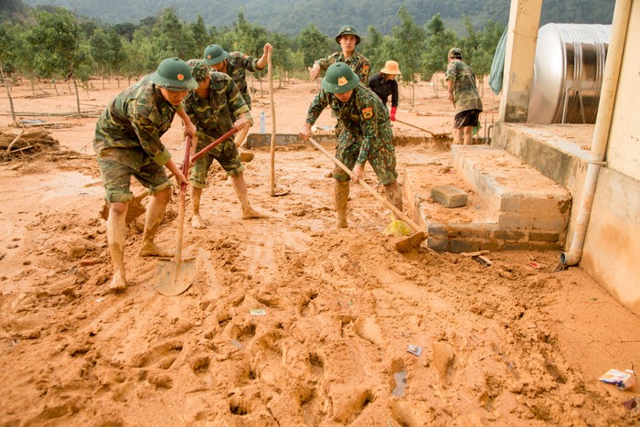 Bộ đội và các cô giáo trường Mầm non Hướng Việt dọn trường sau lũ. Ảnh: Bảo Trung