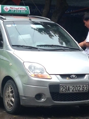 2 chiếc taxi “dù” mang BKS 31F-0085 và 29A-20293 đều do một người đăng ký tên chủ xe là: Vương Văn Bá. hiện là Đội trưởng Đội Thanh tra giao thông Phúc Thọ (Hà Nội).