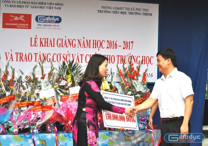 Tổng biên tập Báo điện tử Giáo dục Việt Nam trao phần quà 150 triệu đồng (cơ sở vật chất) và 15 triệu đồng (tiền mặt) cho Hiệu trưởng nhà trường. Ảnh Hải Ninh