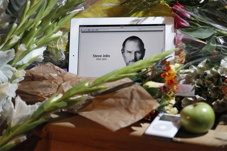 Công chúng tưởng niệm Steve Jobs bằng cách đặt hoa, nến bên một chiếc Ipad mở trang có hình ảnh ông, bên cạnh là một Ipod. Ảnh: Apple.