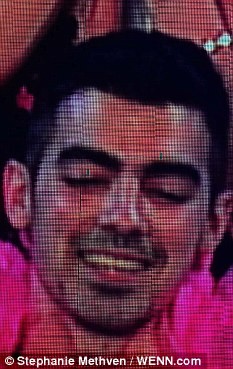 Joe Jonas trông có vẻ đau đớn và xấu hổ khi bà hoàng Britney đu lượn đôi chân ngọc ngà quanh người mình. Trong khi cậu trai trẻ Jonas đỏ lựng mặt thì Britney quấn quanh cổ cậu một dải khăn lông màu hồng và vòng hai tay cậu ra phía sau, còn mình thì thoả sức leo trèo!
