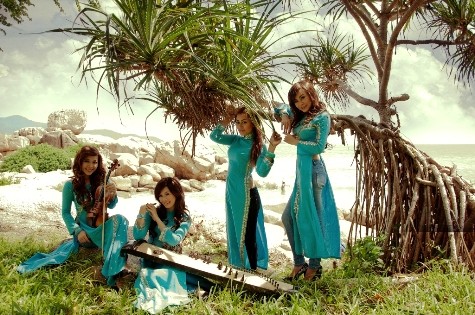 Nhóm nhạc Mặt trời đỏ tạo dáng với trang phục và nhạc cụ truyền thống bên bờ biển Khánh Hòa.