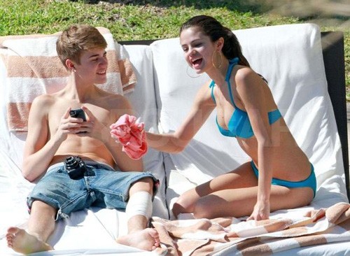 Cặp đôi trong chuyến đi Cabo San Lucas, Mexico ngày 7/12. Justin Bieber cởi trần, mặc jeans ngố, cô bạn gái hơn 2 tuổi Selena Gomez diện bộ bikini 2 mảnh màu xanh biển gợi cảm. Chân trái của giọng ca Baby đang băng bó vì vừa xăm hình.