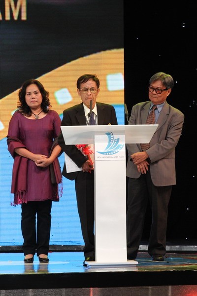 Hoàng Nhuận Cầm (giữa) đọc thơ khi lên nhận giải Biên kịch xuất sắc Phim truyện nhựa.