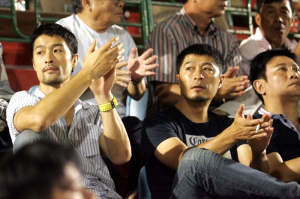 Johnny Trí Nguyễn cùng đạo diễn Charlie Nguyễn (giữa) và diễn viên Hoàng Phúc (phải) có mặt xem trận đấu thuộc khuôn khổ giải bóng đá VĐQG trên sân Gò Đậu, Bình Dương. Trông họ khá "bụi phủi" và đầy nam tính. (Xem chùm ảnh)