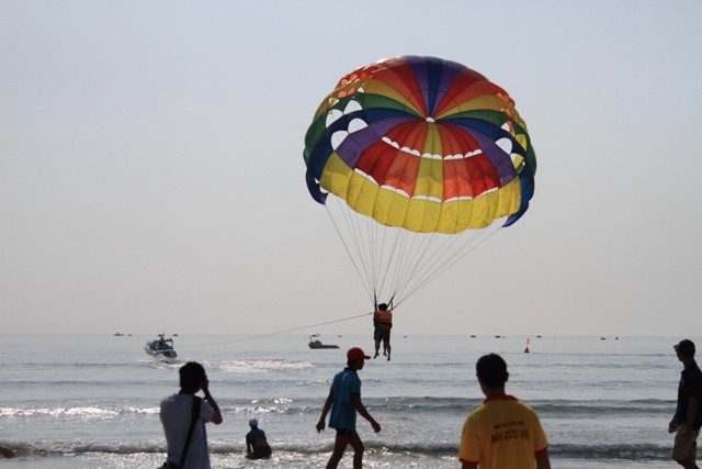 Một số du khách chọn cách ngắm biển Đà Nẵng trên những chiếc dù bay.