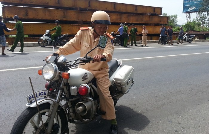 Trung tá Bùi Hòa điều khiển xe mô tô đuổi theo xe container vi phạm và bị ép ngã xuống đường, gây thương tích. Ảnh H.Q