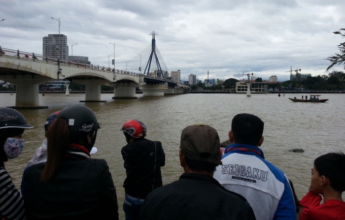 Người dân đang theo giõi việc tìm kiếm thi thể của nạn nhân trên sông Hàn. Ảnh T.Linh