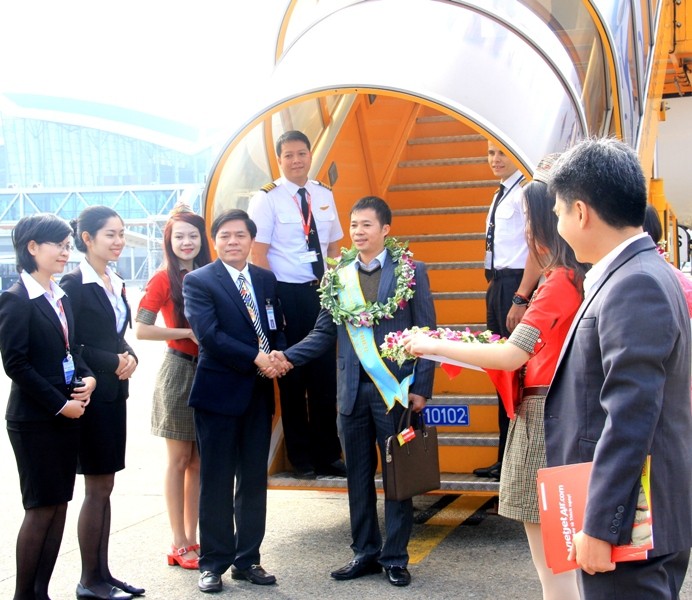 Hành khách thứ 5 triệu (ở giữa) may mắn nhận được 1 năm bay miễn phí cùng Vietjet. Ảnh Thùy Linh