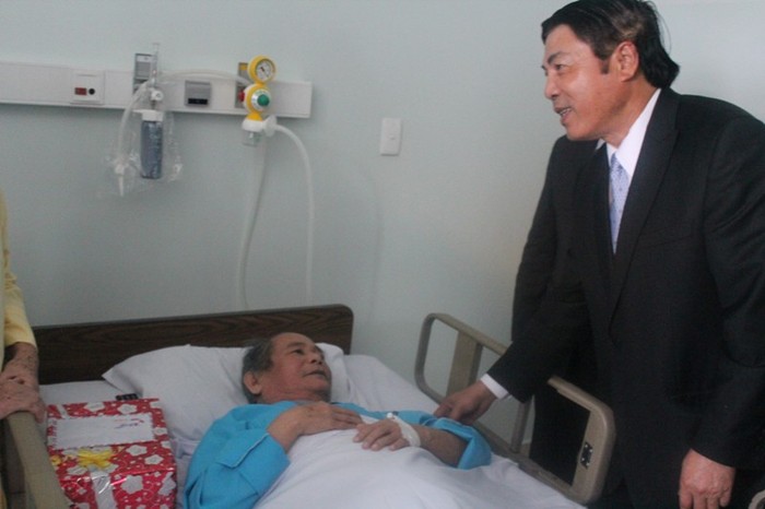 Ông Nguyễn Bá Thanh (người đứng, mặc comple tối màu) trong một lần thăm bệnh nhân ung thư tại Bệnh viện Ung thư Đà Nẵng. Ảnh Thùy Linh