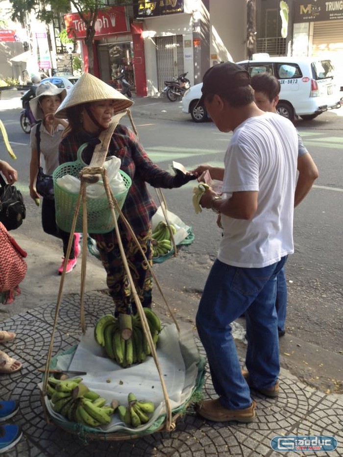 Một nhóm khách du lịch Trung Quốc vừa bẻ chuối vừa ăn rồi ném vỏ chuối vào giỏ của người bán chuối hàng rong bị nhạc sĩ Nguyễn Duy Khoái ghi lại. Ảnh: Nhạc sĩ Nguyễn Duy Khoái