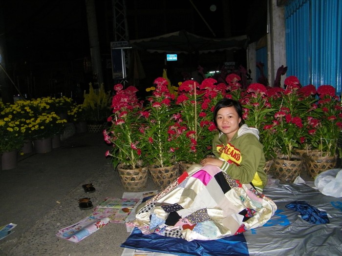 Cô gái tên My đang thức canh những chậu hoa, thay phiên cho người chị mình đang ngủ. Ảnh chụp trước cổng trường THCS Lê Lợi (ngã 6 Dân Chủ, Q3).