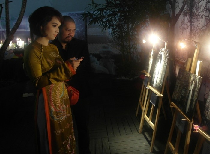 Nhà thiết kế Đức Hùng và diễn viên Mai Thu Huyền đang đứng trước các bức ảnh của Hoàng Thuỳ.