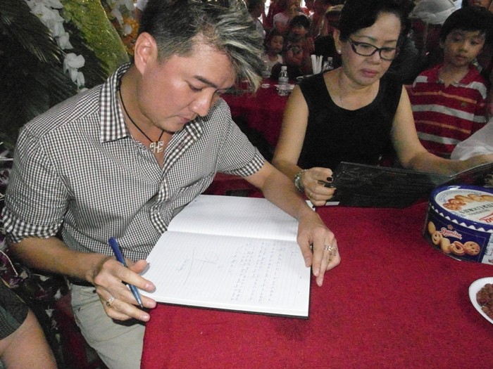 Bà Lương Minh Hồng chăm chú xem tập bản thảo những bài hát của cố nhạc sĩ Thanh Sơn.