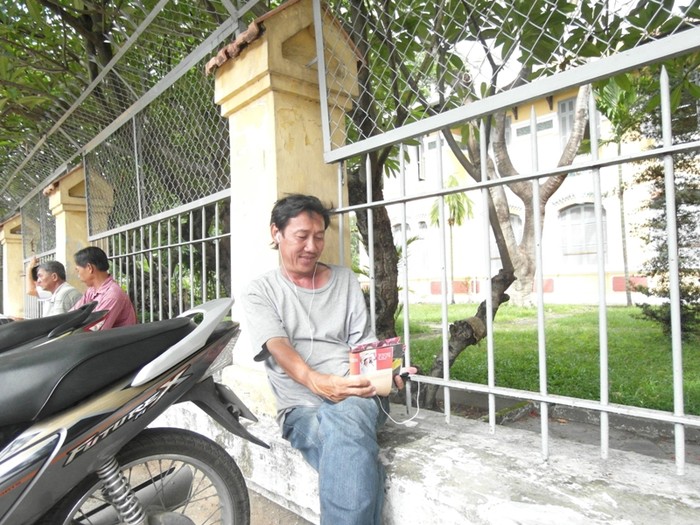 Vị phụ huynh này khá sành điệu với tai phone nghe nhạc bằng điện thoại trong thời gian chờ con trước cổng trường Nguyễn Thị Minh Khai.