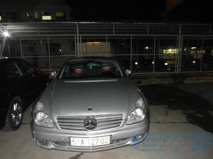 Chiếc xe Mercedes màu bạc nằm đợi chủ nhân ở ngoài sân.