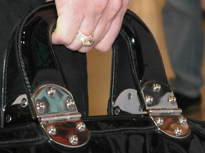 Trên bàn tay phải là...chiếc nhẫn kim cương bạc tỷ, hài hòa với chiếc túi đắt tiền.