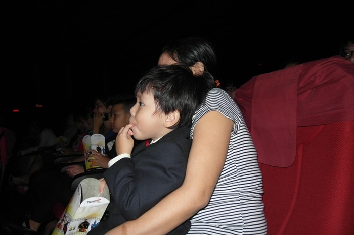 Người bảo mẫu ôm đứa con trai út của vợ chồng Kim Thư - Phước Sang vào lòng.