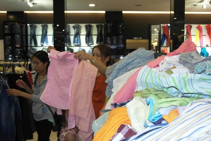 Hàng giảm giá chất đống trong cửa hàng The Blue, có giá từ 30 ngàn cho đến 120 ngàn/chiếc. Người phụ nữ này lựa mãi, vẫn không chọn được cho mình cái áo nào vừa ý.