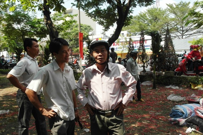 Người đàn ông (bên tay phải) đang mặc cả với anh Lê Sỹ Thuận, muốn mua chậu đào với giá 300 ngàn đồng. Anh Thuận không chịu: "Anh ơi, em lỗ lắm rồi. Giá 400 ngàn là em đã chịu lỗ so với giá gốc rồi đấy".