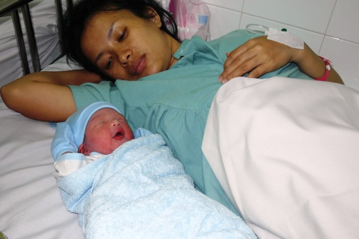 Bà mẹ Lưu Thị Kiều Nương bên đứa con trai kháu khỉnh nặng 3,15 ký, chào đời lúc 0 giờ 5 phút ngày mồng 1.1.2013.