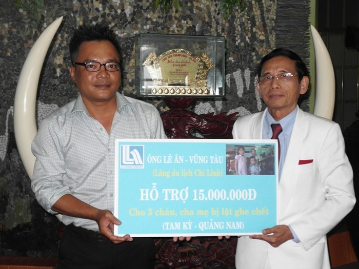 Phóng viên báo điện tử Giáo dục Việt Nam nhận bảng tượng trưng 15 triệu đồng từ tay ông Lê Ân, gửi đến cho 3 cháu bé bất hạnh trong vụ đắm thuyền ở Quảng Ngãi.