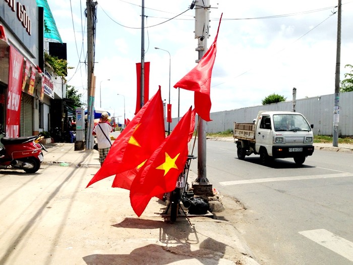 Cờ đỏ sao vàng được bày bán trên đường Nguyễn Hữu Thọ, Quận 7.