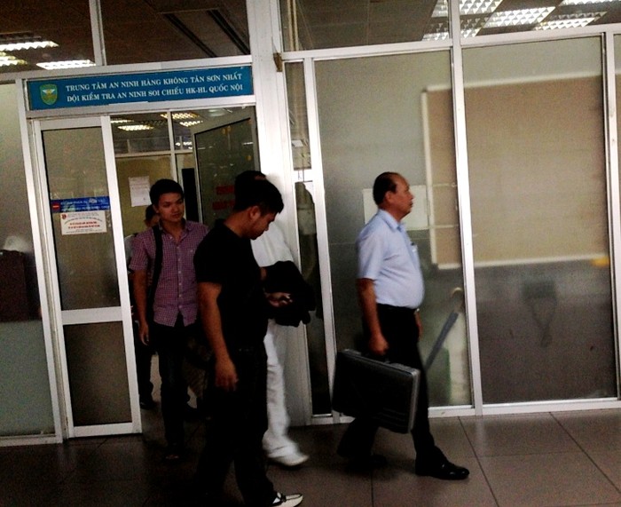 Làm thủ tục khoảng 15 phút, các nhân viên an ninh Hà Nội, cùng an ninh sân bay đã mau chóng đưa ông Nguyễn Hữu Khai ra máy bay.Ông Khai trong bộ đồ khá đống nhất: Quần trắng, áo trắng, giày trắng.