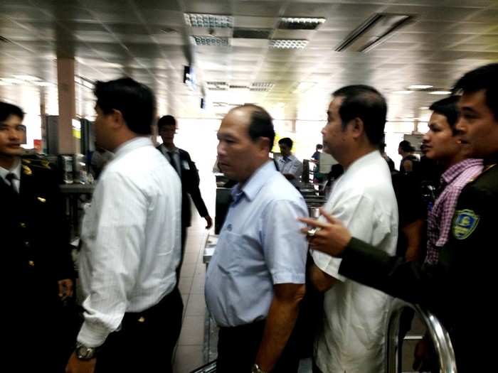Và đứng xếp hàng như mọi người. Đứng cạnh ông là một nhân viên an ninh sân bay.(Ông Nguyễn Hữu Khai mặc áo trắng đi phía sau cùng)