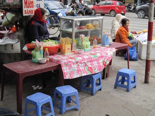 Nhiều chủ hàng ăn trên vỉa hè co ro đợi khách trong những ngày đầu thực hiện lệnh cấm trông giữ xe trên 262 tuyến phố Hà Nội.