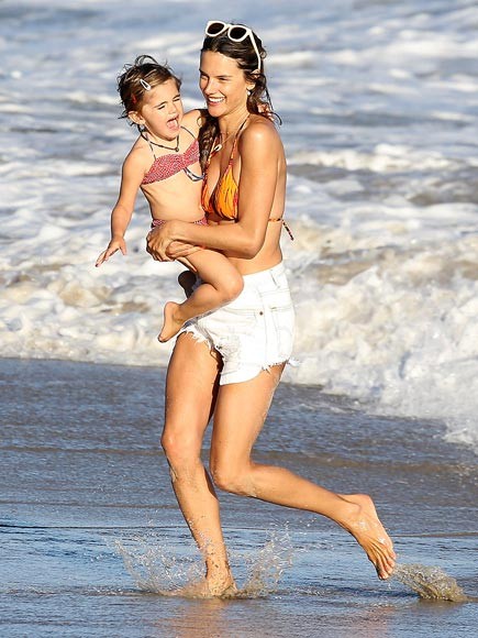 Siêu mẫu Alessandra cùng cô con gái 3 tuổi trên biển Malibu, California. Cô bé có vẻ đang sợ hãi điều gì đó.