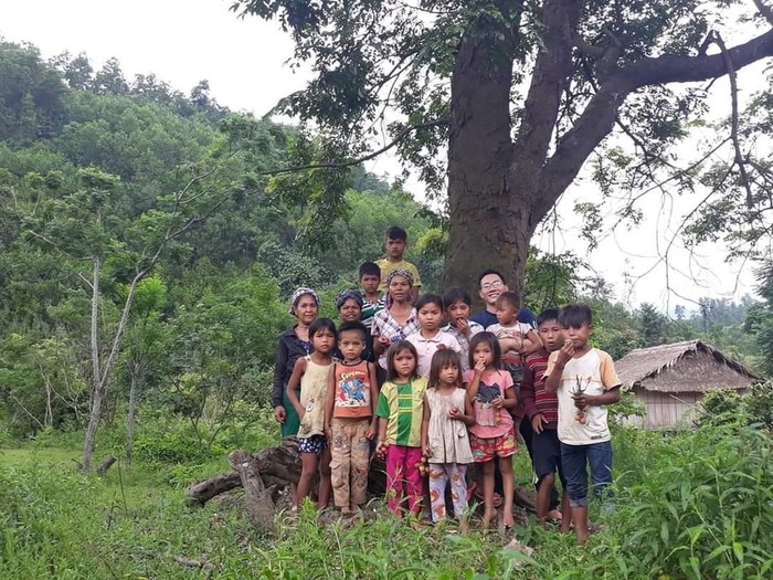Thầy giáo Trần Mạnh Hùng (đeo kính) chụp ảnh cùng các em nhỏ trong vùng. Ảnh: NVCC