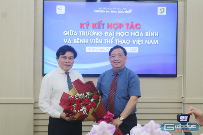 Hiệu trưởng Trường Đại học Hòa Bình tặng hoa Giám đốc Bệnh viện Thể thao Việt Nam. Ảnh: DN