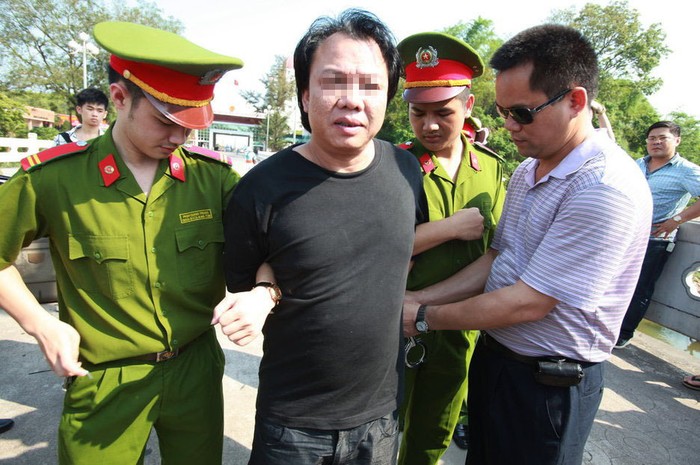 Cán bộ mở còng tay tội phạm để bàn giao cho cảnh sát Trung Quốc