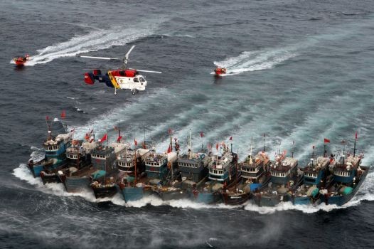 Tàu cá Trung Quốc thường đi theo tốp xâm nhập trái phép và tranh thủ đánh bắt trái phép tại vùng biển nước khác, dàn hàng ngang đối phó với lực lượng kiểm tra. Ảnh chụp tháng 11 năm ngoái, trực thăng, xuồng cảnh sát biển Hàn Quốc phát hiện và truy đuổi