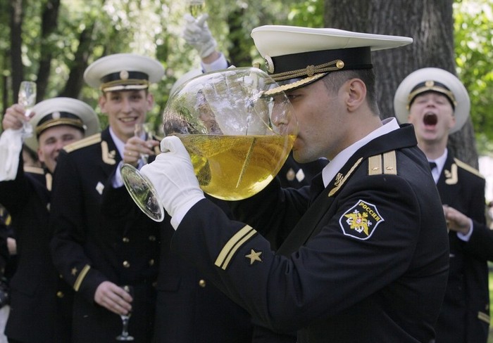 Những chiếc ly "khủng" đựng đầy rượu và nhúng thanh đoản đao tốt nghiệp của chính mình được một tân sỹ quan trẻ nâng lên uống trong tiếng reo hò cổ vũ của đồng đội