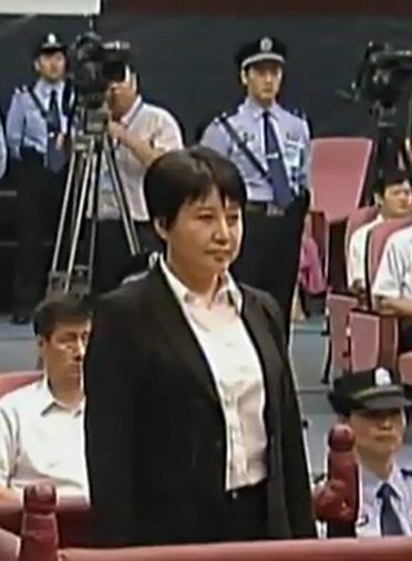 Bà Cốc Khai Lai trước tòa, không phản bác, cũng không run sợ với gương mặt lạnh lùng đến khó hiểu. Dường như bà Cốc béo khỏe hơn so với những bức hình chụp trước khi bị bắt