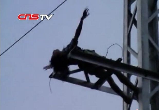Người phụ nữ phát điên vì chồng bỏ trèo lên cột điện cao 15 mét hò hát (ảnh chụp từ clip)