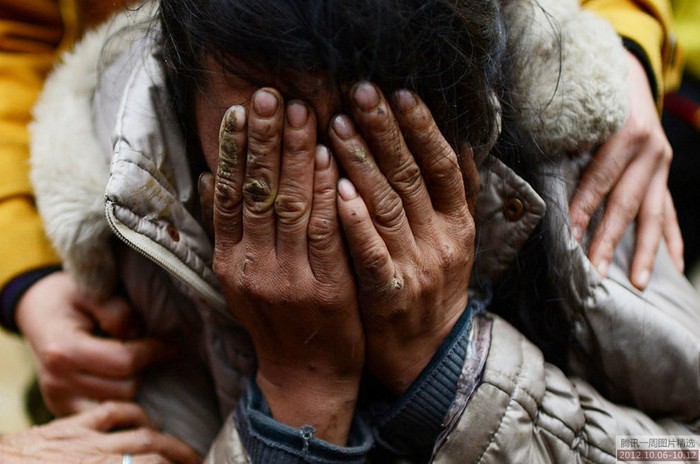 Một người mẹ mất con trong vụ lở núi vùi lấp 13 học sinh ở Vân Nam, Trung Quốc ngày 8/10 ôm mặt khóc nức nở