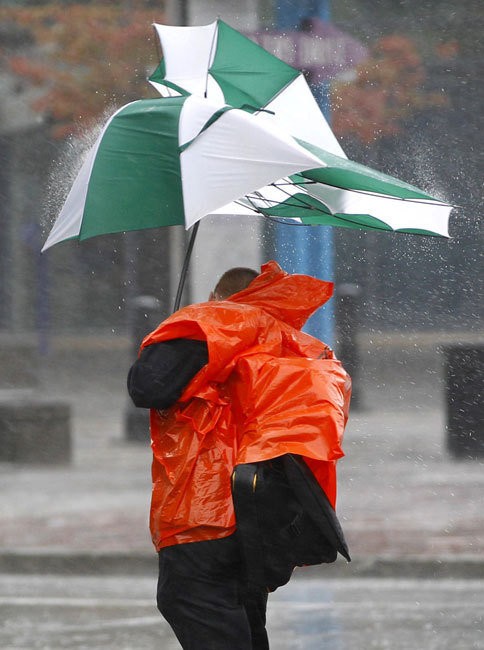 Mưa to, gió lớn xé rách chiếc ô của một người dân trên đường về nhà trước khi bão đổ bộ