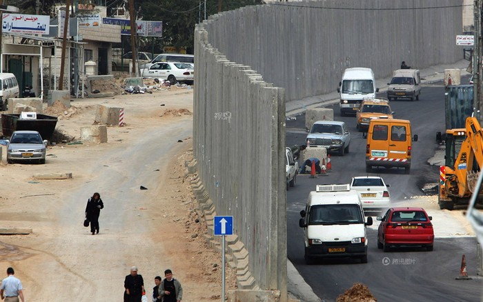 Một bức tường sơ sài ngăn cách 2 thế giới, một bên là người Palestin, một bên là người Israel