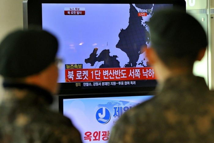 2 người lính Hàn Quốc theo dõi bản tin về vụ phóng tên lửa qua truyền hình