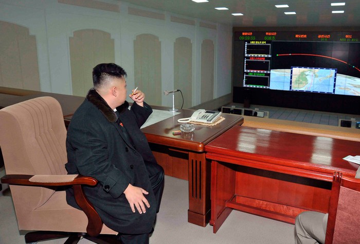 Kim Jong-un hút thuốc ngồi theo dõi đường đi của tên lửa Unha-3 trên màn hình