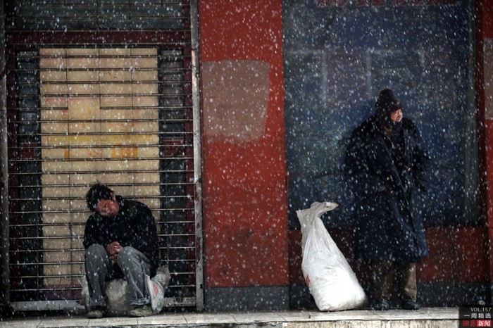 Một người đàn ông co ro trong trận mưa tuyết đầu tiên ở Trịnh Châu, thủ phủ tỉnh Hà Nam, Trung Quốc ngày 13/12