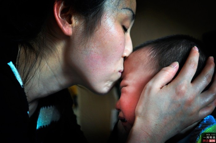 Lý Duyệt, một phụ nữ Thiểm Tây, Trung Quốc sung sướng ôm hôn đứa con thất lạc sau 1 năm đã tìm lại được. Ảnh chụp sáng 8/12